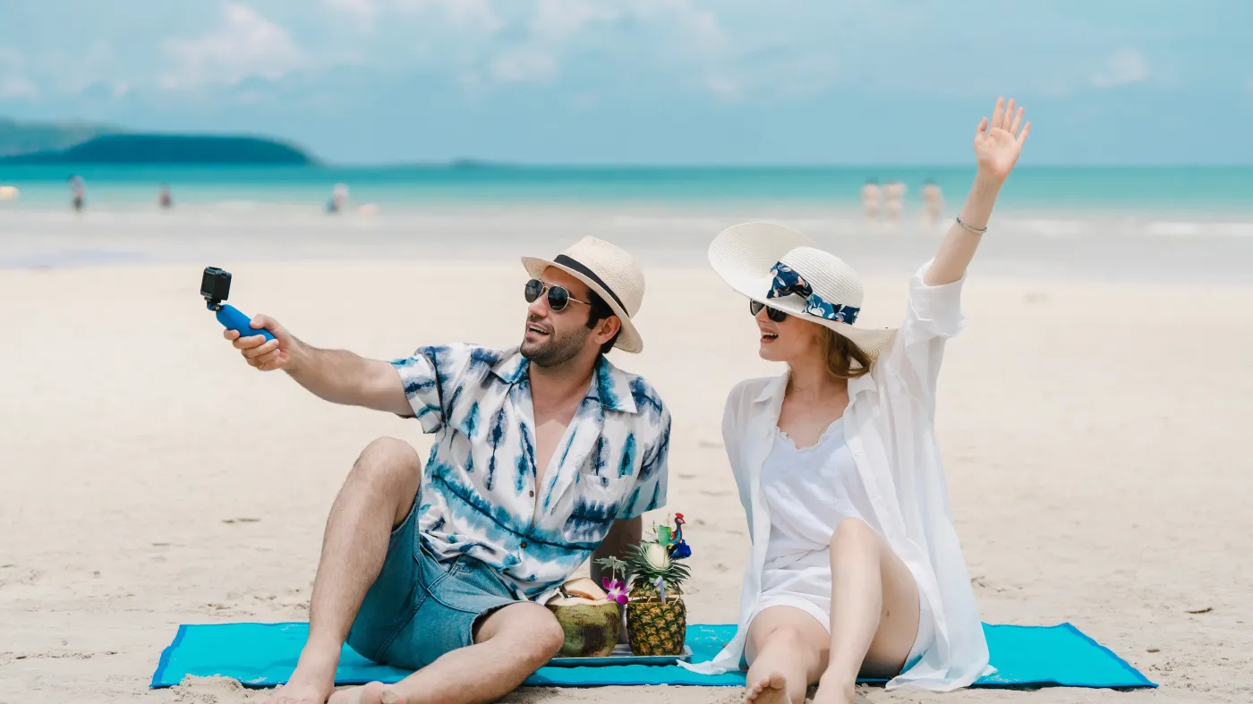 mężczyzna i kobieta robią sobie zdjęcie na plaży