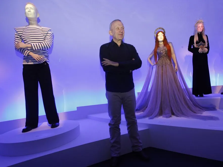 Jean Paul Gaultier na tle wystawy swoich projektów zatytuowanej „The Fashion Word of Jean Paul Gaultier”