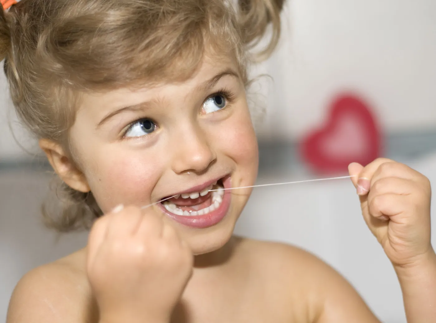 Dziecko używa nici dentystycznej