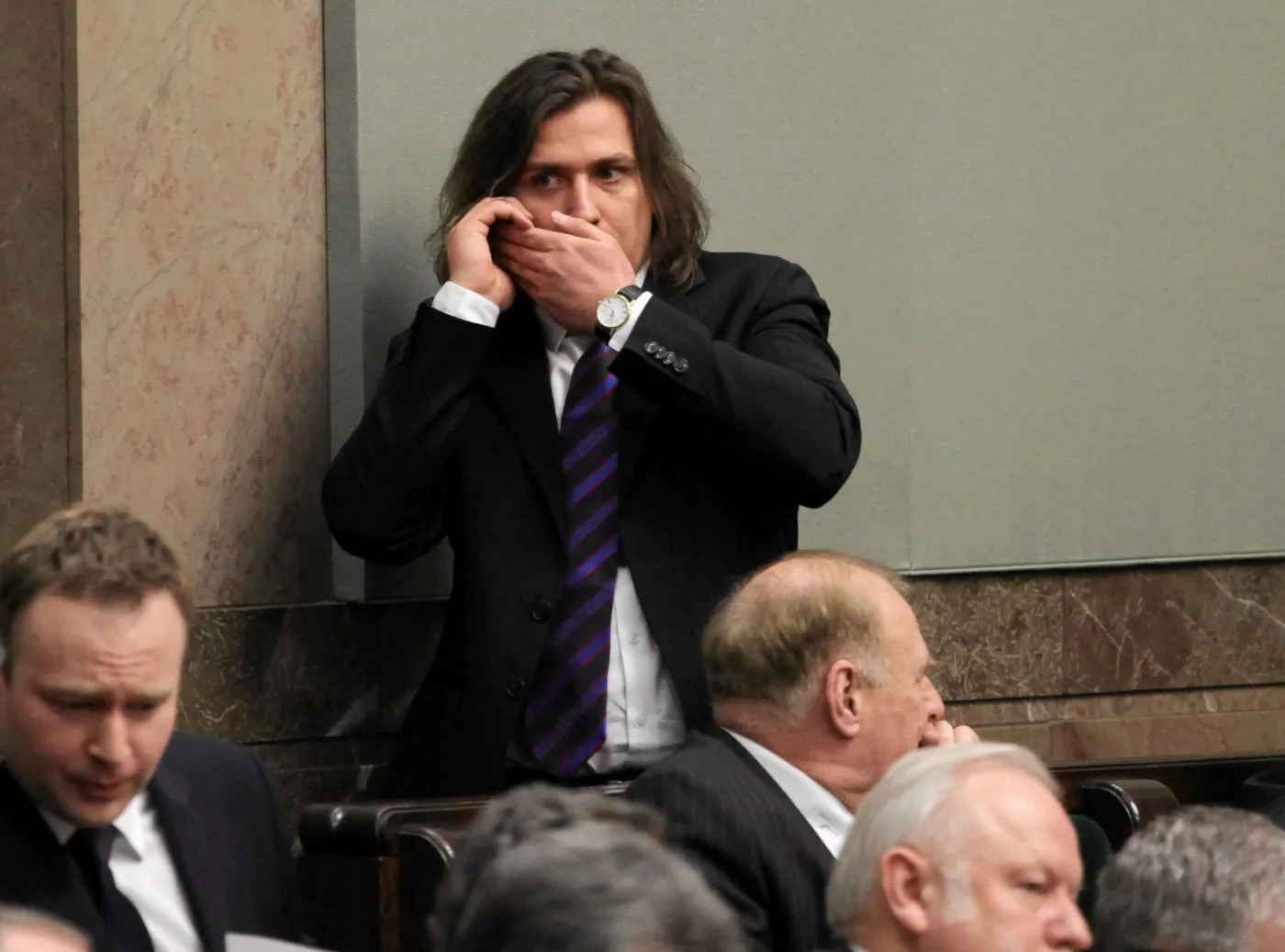 Poseł Tomasz Kaczmarek rozmawia w Sejmie przez telefon komórkowy