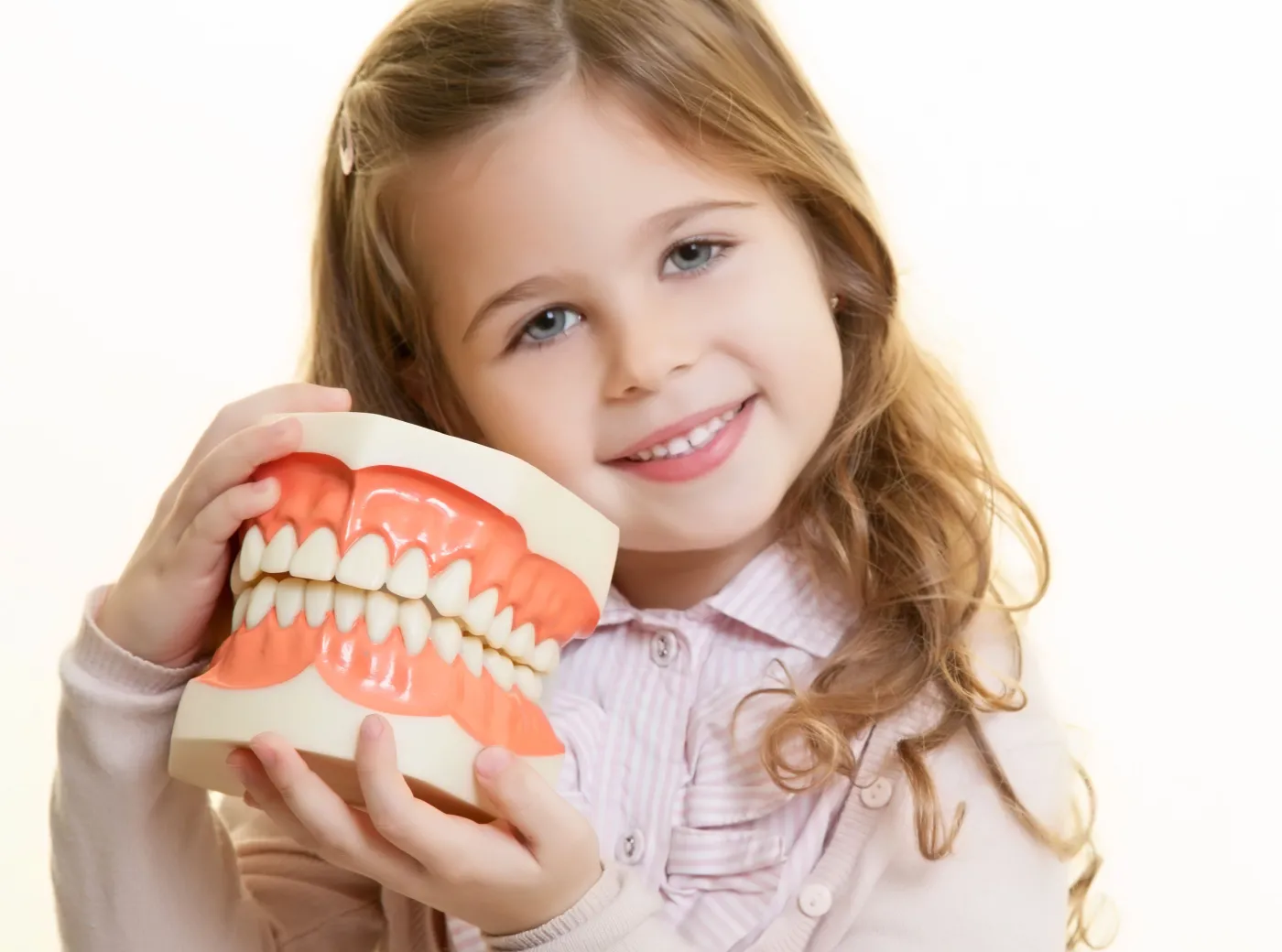 Dziewczynka trzyma sztuczną szczękę