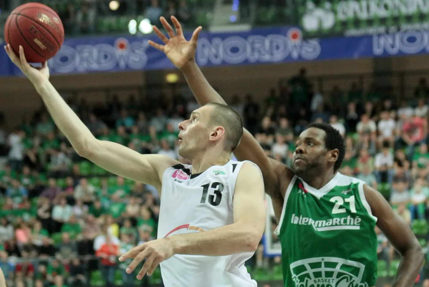 Będący przy piłce Filip Dylewicz (L) z PGE Turów Zgorzelec blokowany przez Craiga Brackinsa (P) z miejscowego Stelmetu w czwartym finałowym meczu play off ekstraklasy koszykarzy, rozegranym w Zielonej Górze
