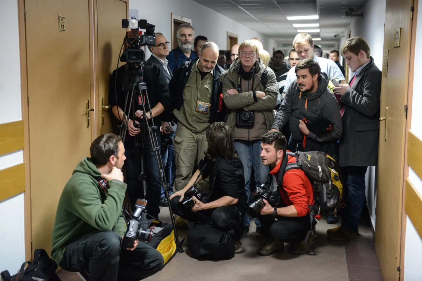 Dziennikarze na korytarzu sądu rejonowego w Warszawie czekają na proces dziennikarzy zatrzymanych przez policję w siedzibie PKW