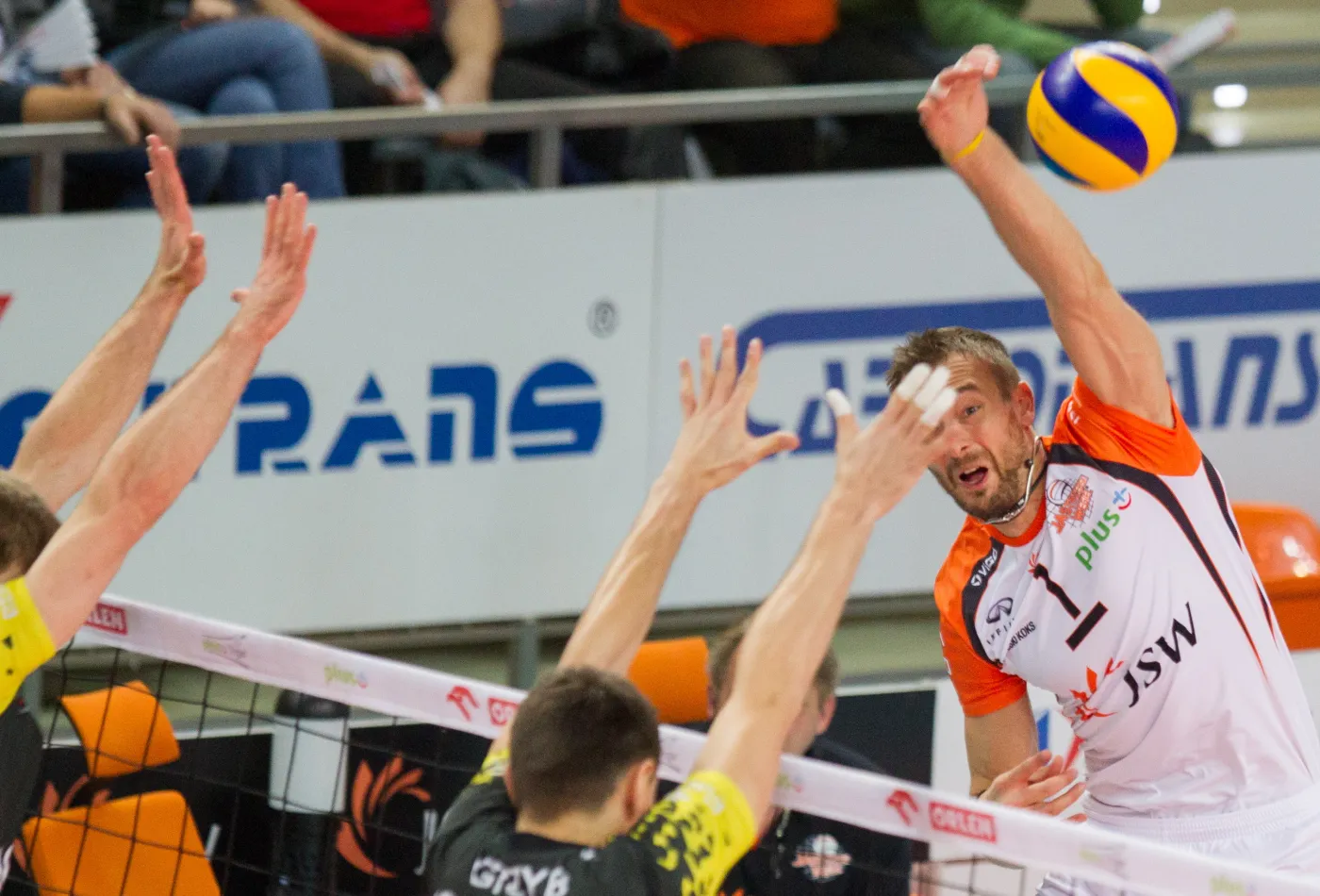 Piłkę zbija atakujący po drugiej stronie siatki Michał Łasko (P) z Jastrzębskiego Węgla nad blokiem Wojciecha Grzyba (C) Lotosu Trefl Gdańsk