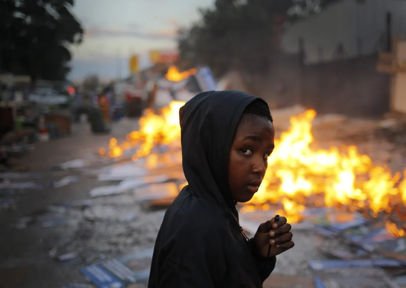 epa04447326 YEARENDER 2014 JUNE A young boy walks past a burning fire used to keep evicted families warm overnight after police and private security evicted families from a commercial property in Johannesburg, South Africa, 05 June 2014.  EPA/KIM LUDBROOK  Dostawca: PAP/EPA. Dostawca: PAP/EPA.