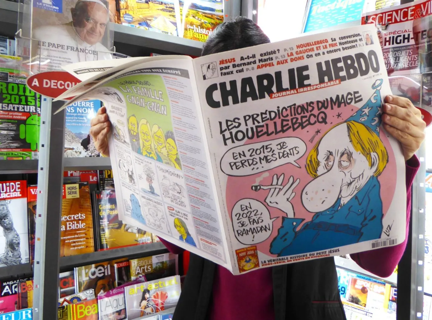 Mężczyzna czyta tygodnik "Charlie Hebdo"