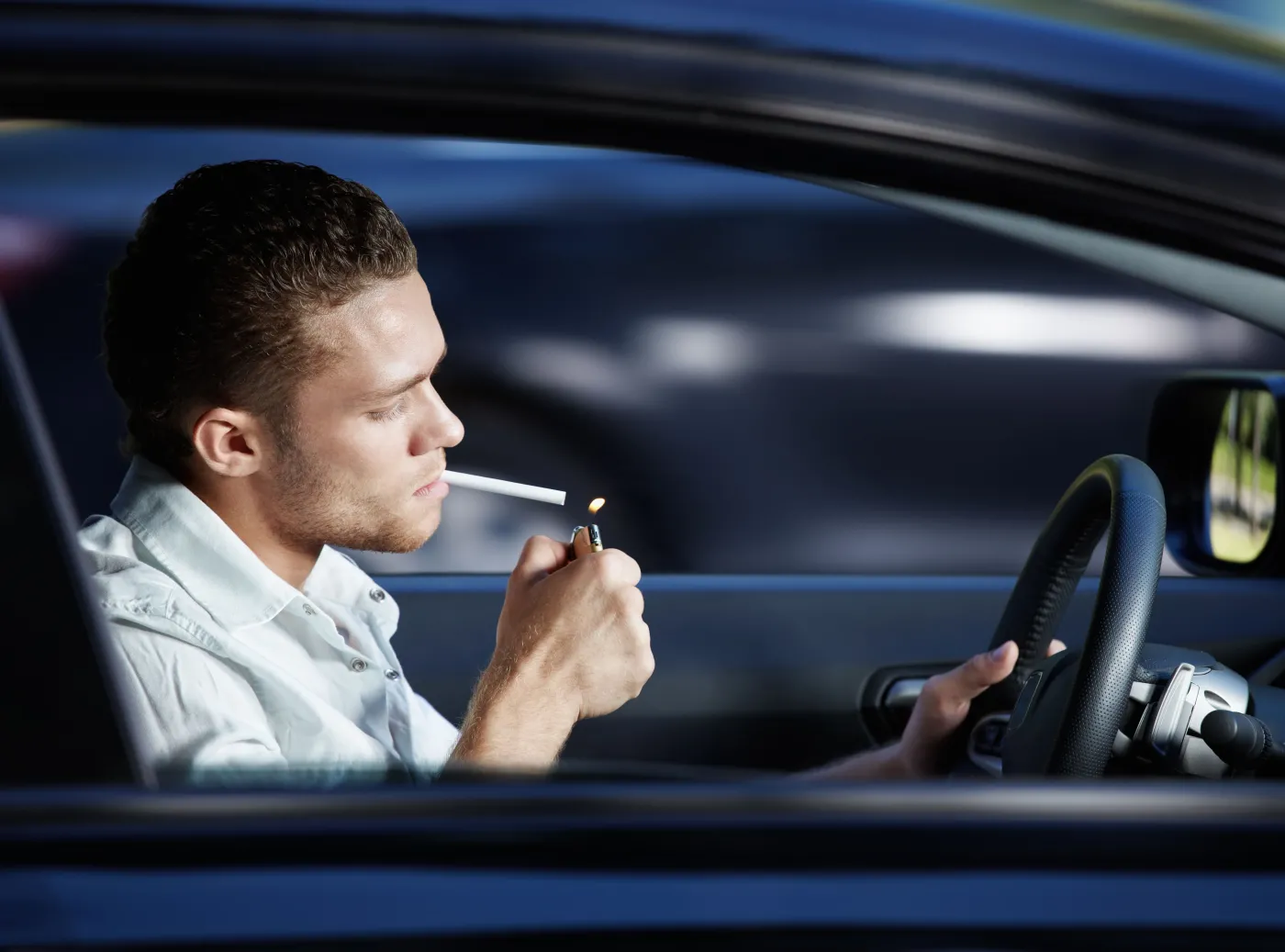 Mężczyzna pali papierosa w samochodzie