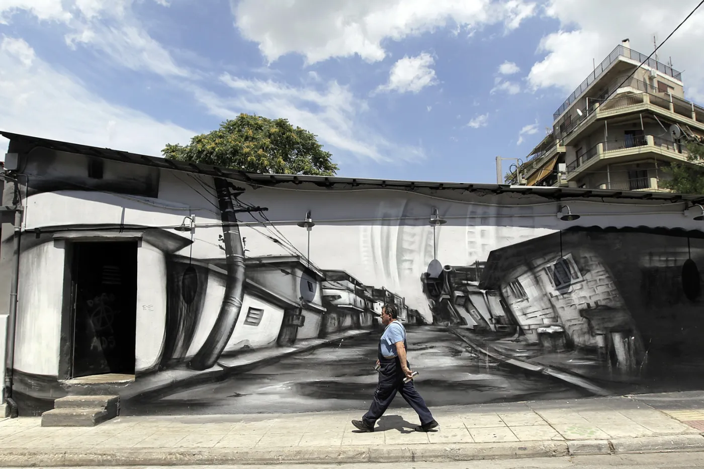 Robotnik na tle murala w Atenach