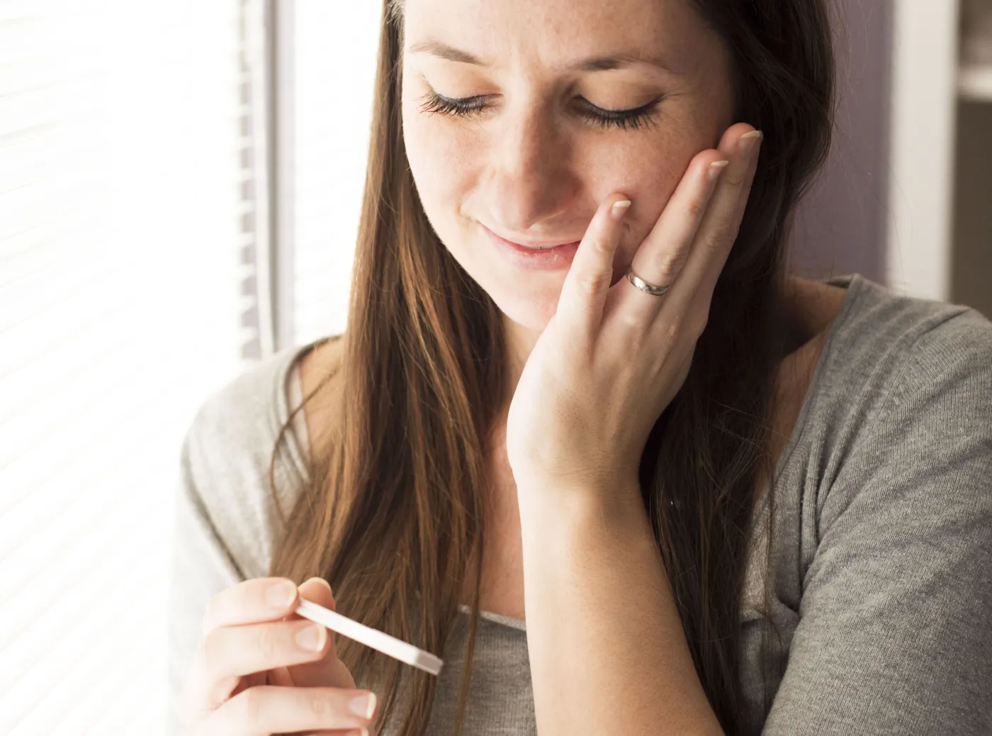 Kobieta patrzy na test ciążowy