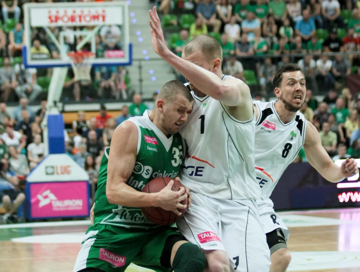 Zawodnik Stelmetu Zielona Góra Przemysław Zamojski (L) blokowany przez Damiana Kuliga (C) z PGE Turów Zgorzelec podczas 4. meczu finałowego Ekstraklasy koszykarzy, 4 bm. Z prawej biegnie Michał Chyliński. 