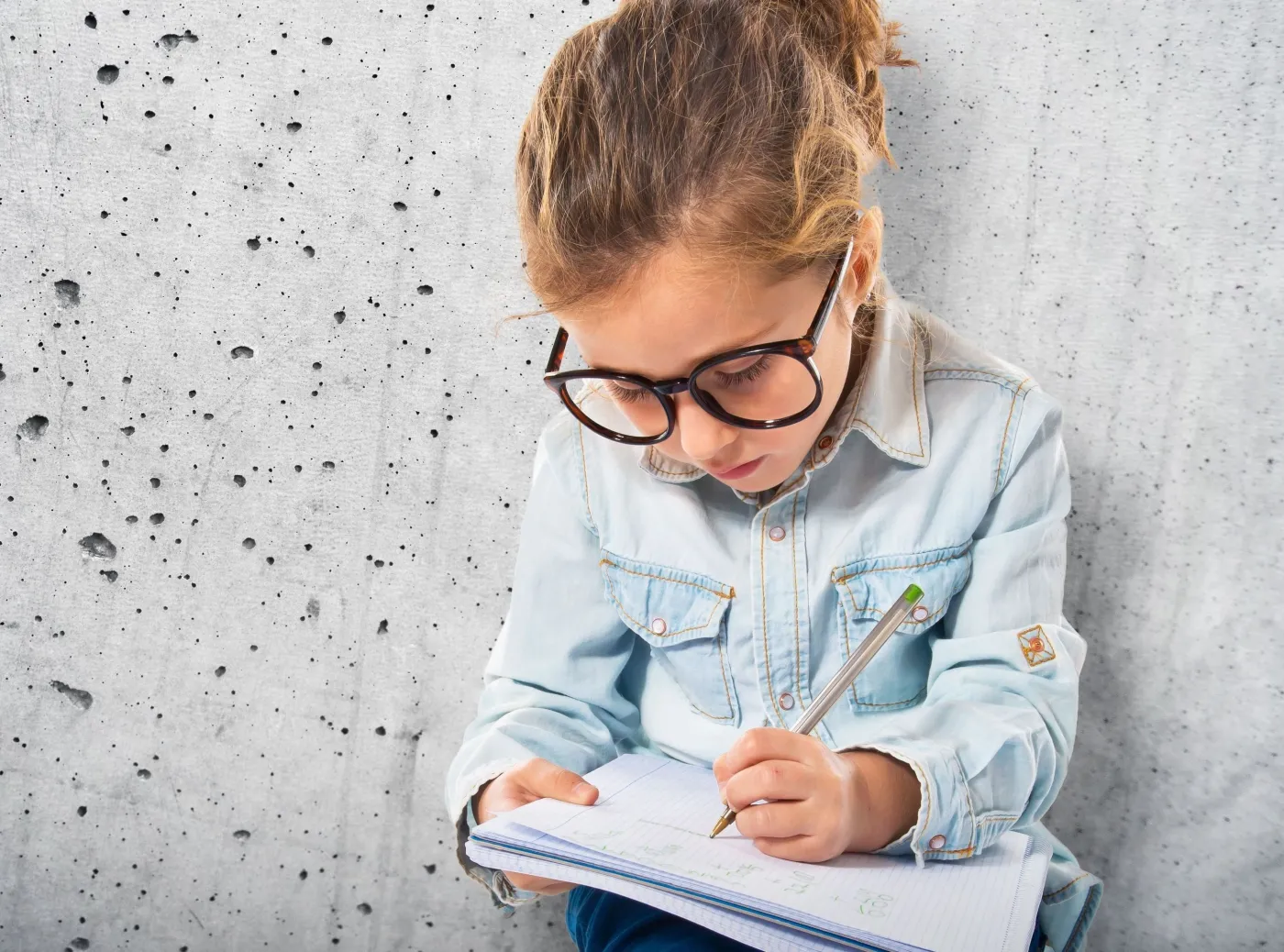 Mała dziewczynka pisze w zeszycie
