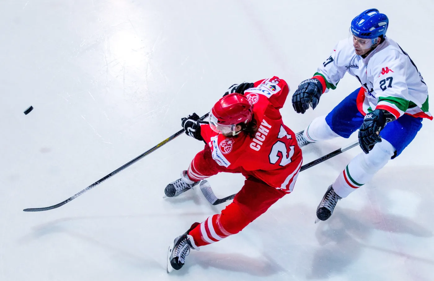 Michael Cichy (L) walczy o krążek z Włochem Jarim Monferrone'm (P) podczas meczu hokejowego turnieju EIHC w Katowicach