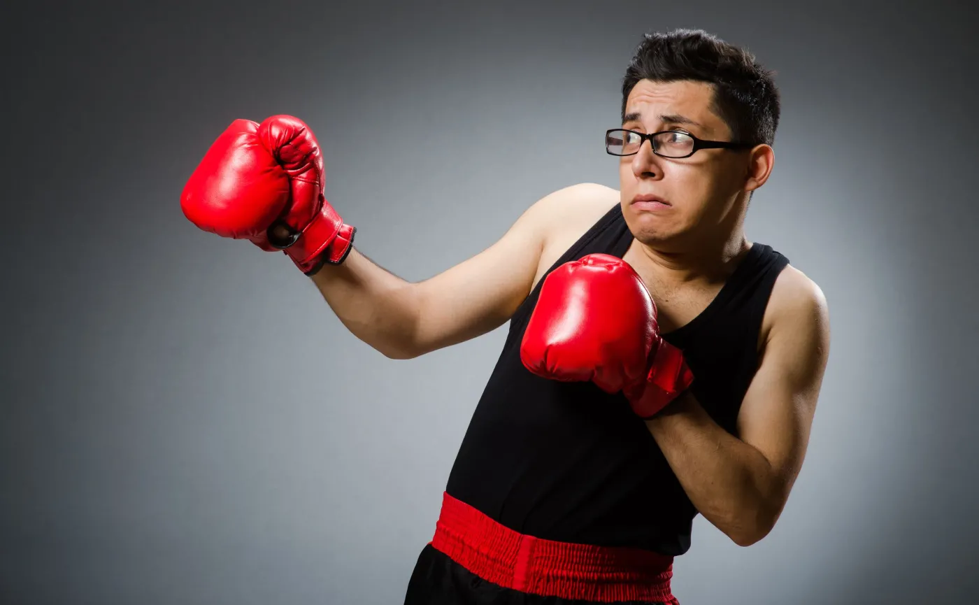 Słaby mężczyzna trenuje boks