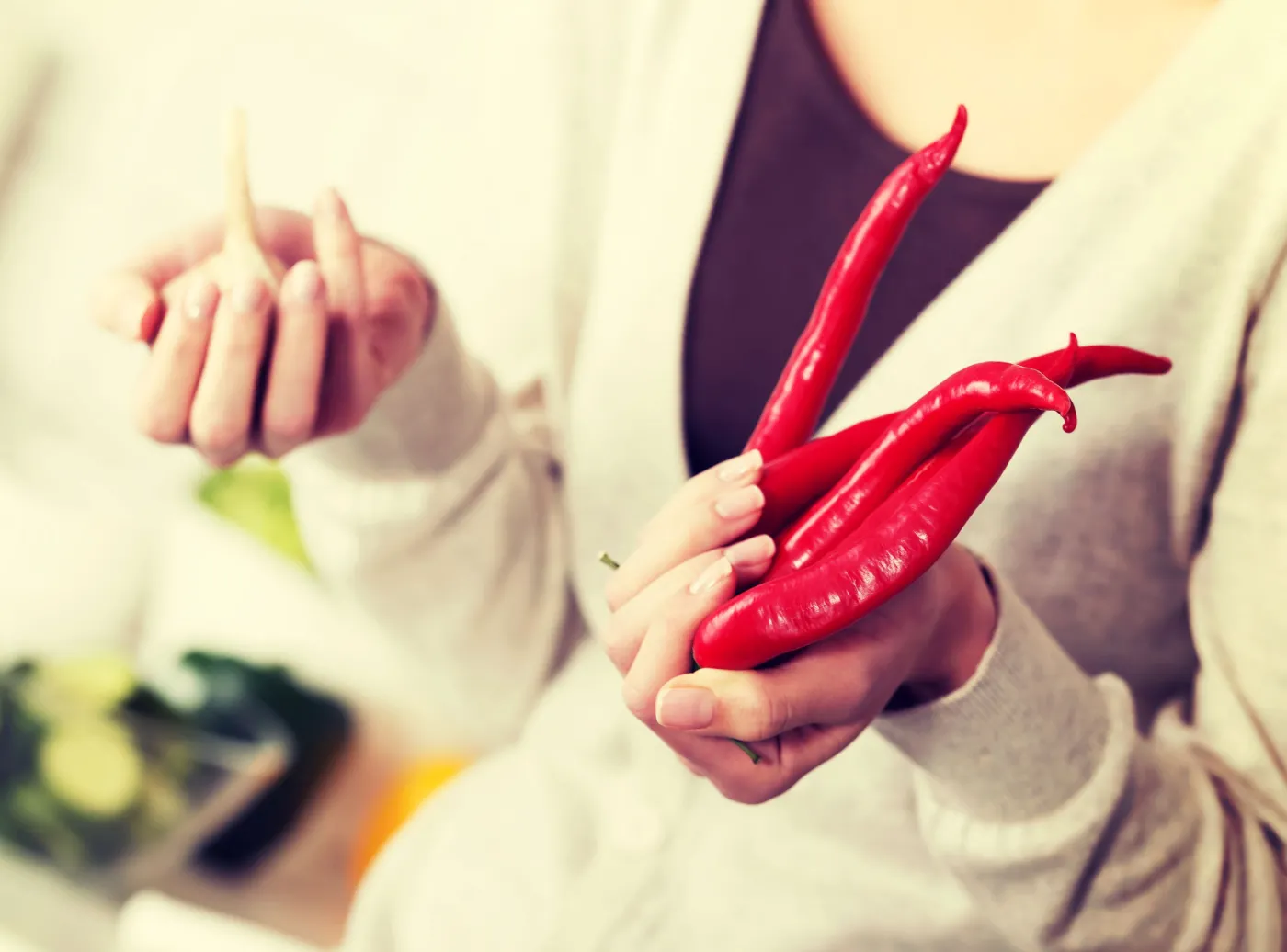 Kobieta trzyma w dłoniach chili i czosnek