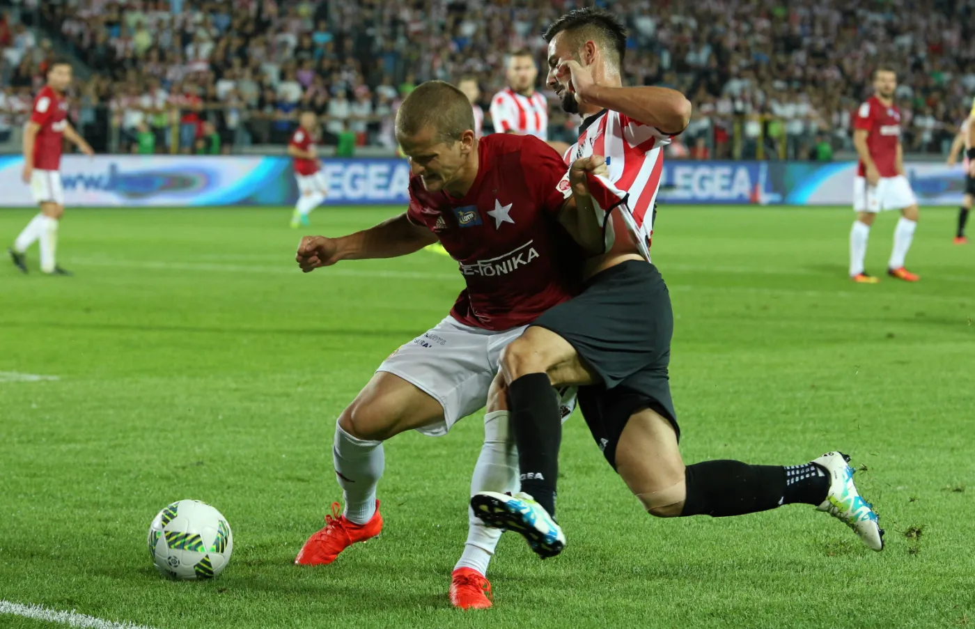 Piłkarz Cracovii Tomas Vestenicky (P) i Tomasz Cywka (L) z Wisły Kraków