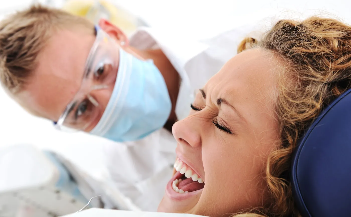 Kobieta krzyczy na fotelu dentystycznym