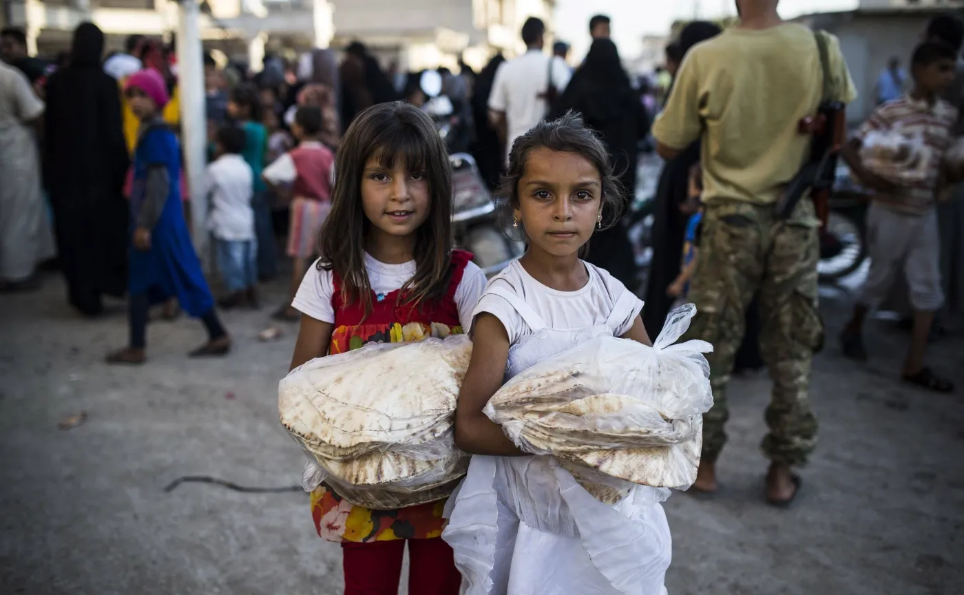 Dziewczynki z Aleppo niosące dary pomocy humanitarnej