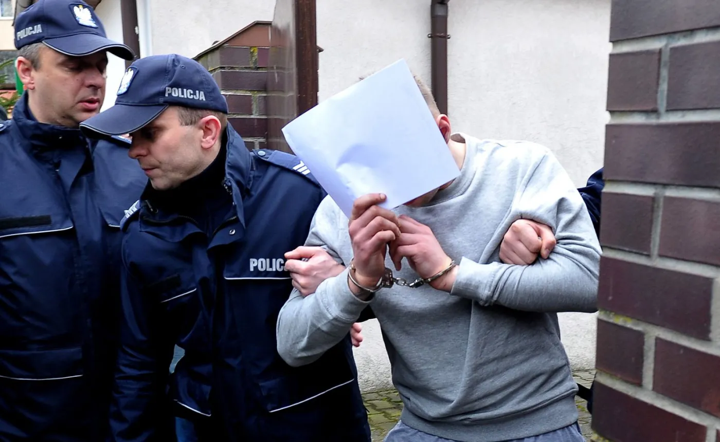 Jeden z zatrzymanych wyprowadzany przez policję po przesłuchaniu w Prokuraturze Rejonowej w Kamieniu Pomorskim