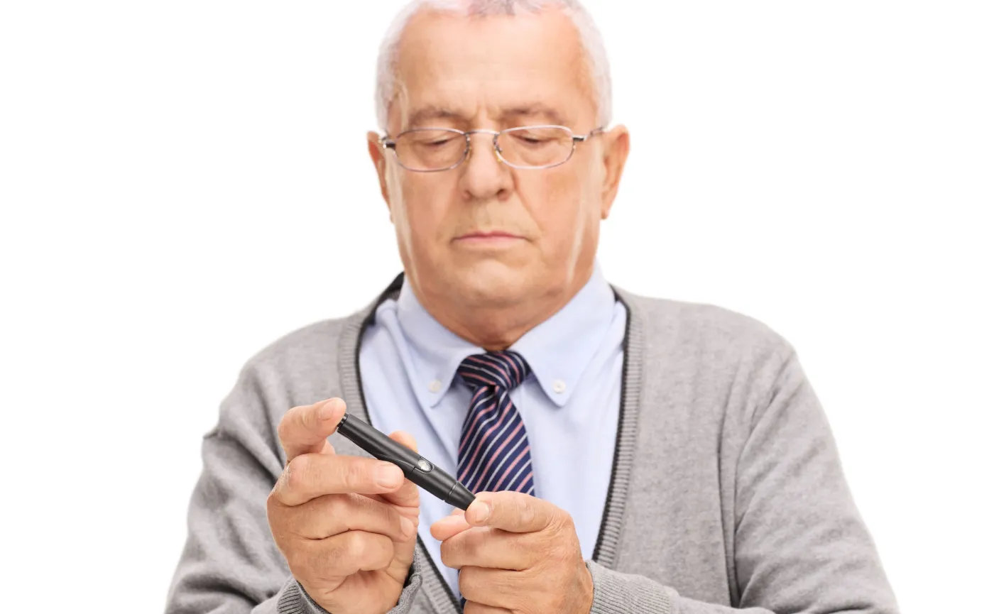 Starszy mężczyzna bada się glukometrem