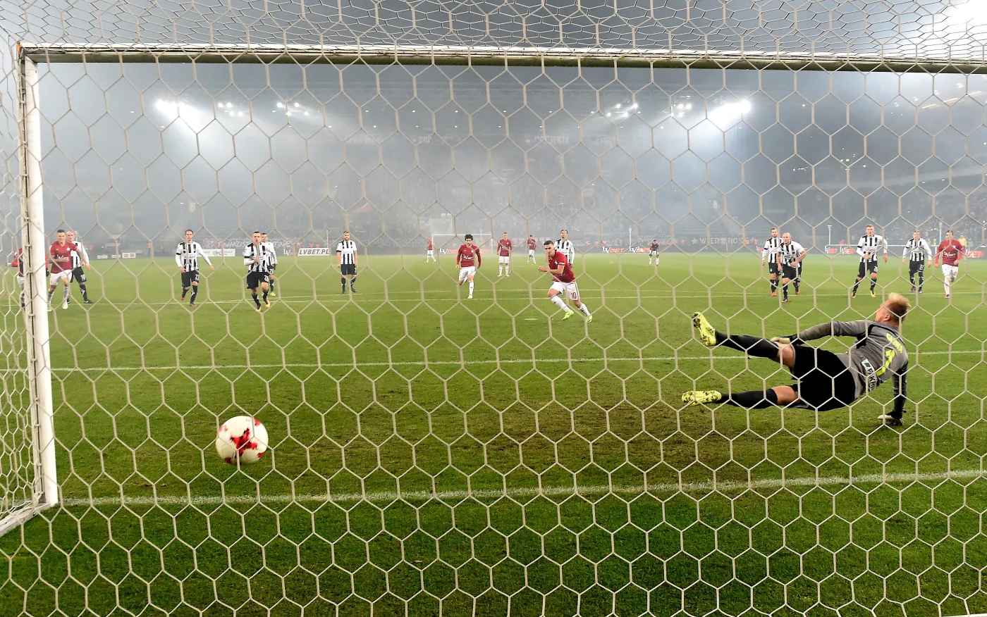 Piłkarz Wisły Kraków Carlitos (C) pokonuje z rzutu karnego Michała Gliwę (P) z Sandecji Nowy Sącz