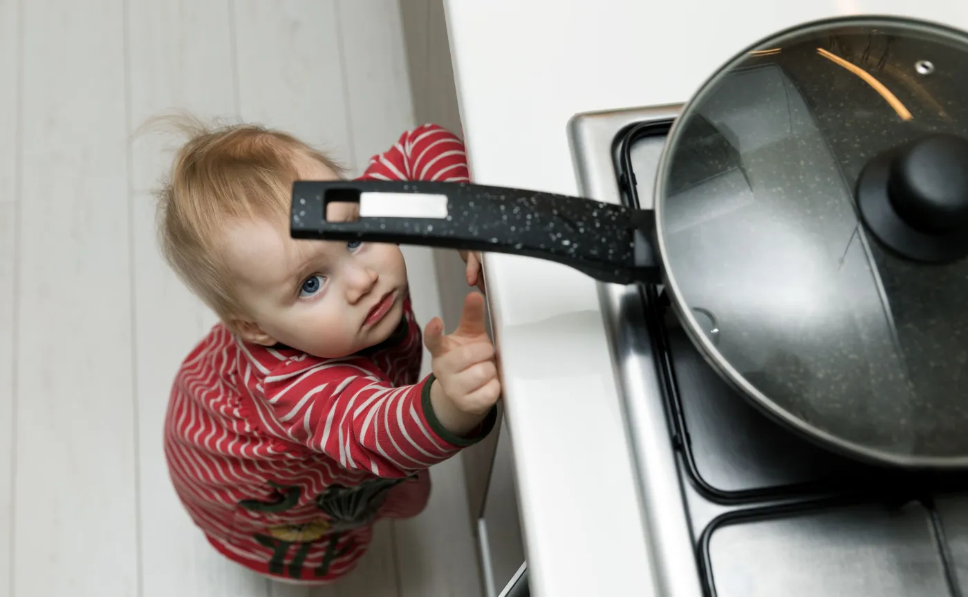 Dziecko sięga po gorący garnek