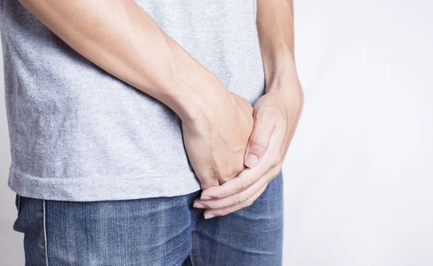 Mężczyzna trzyma się za krocze