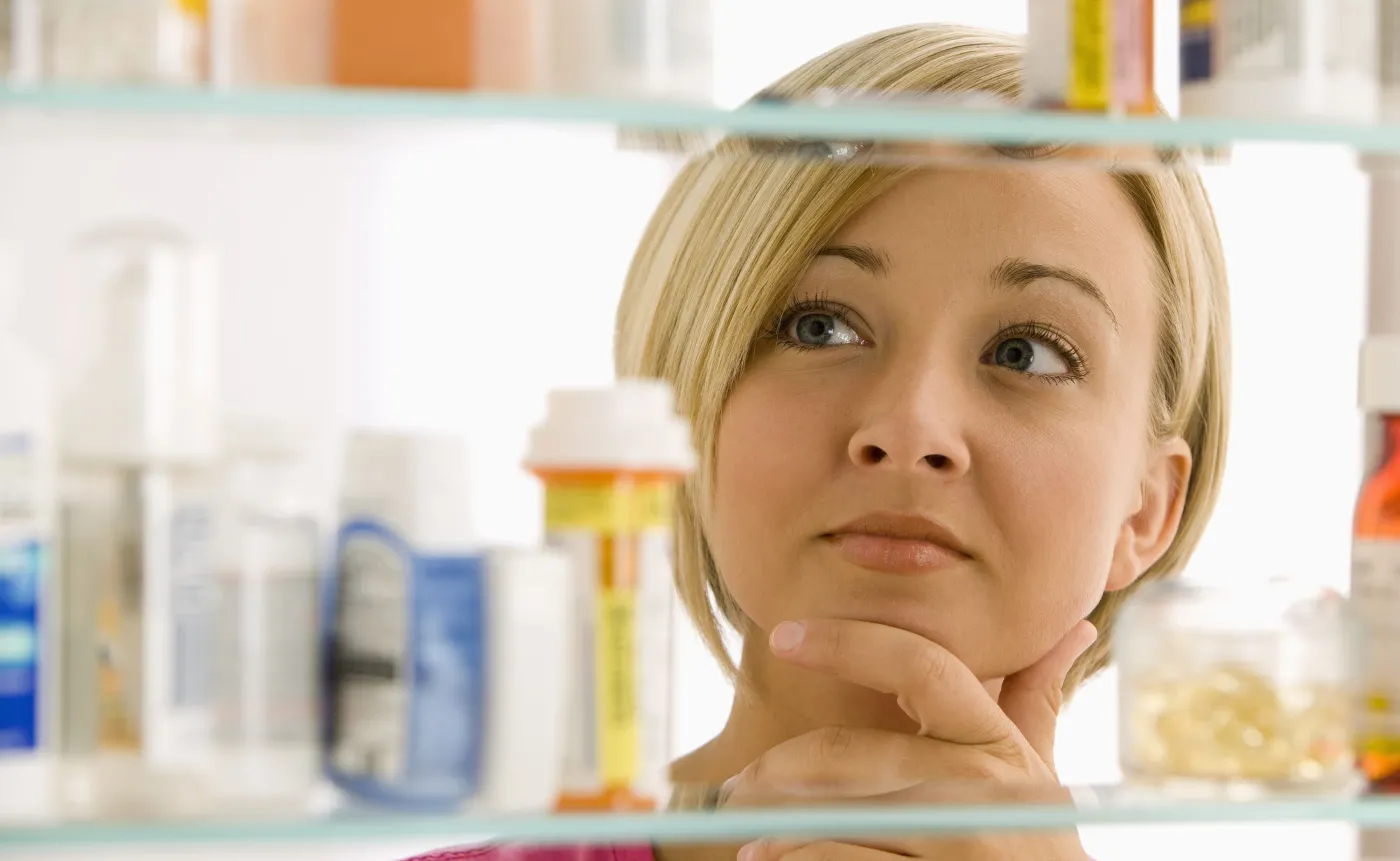 Kobieta stoi przed półką z lekami