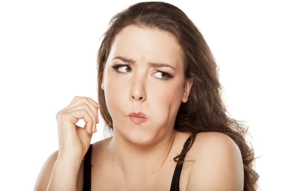 Kobieta dotyka językiem zębów
