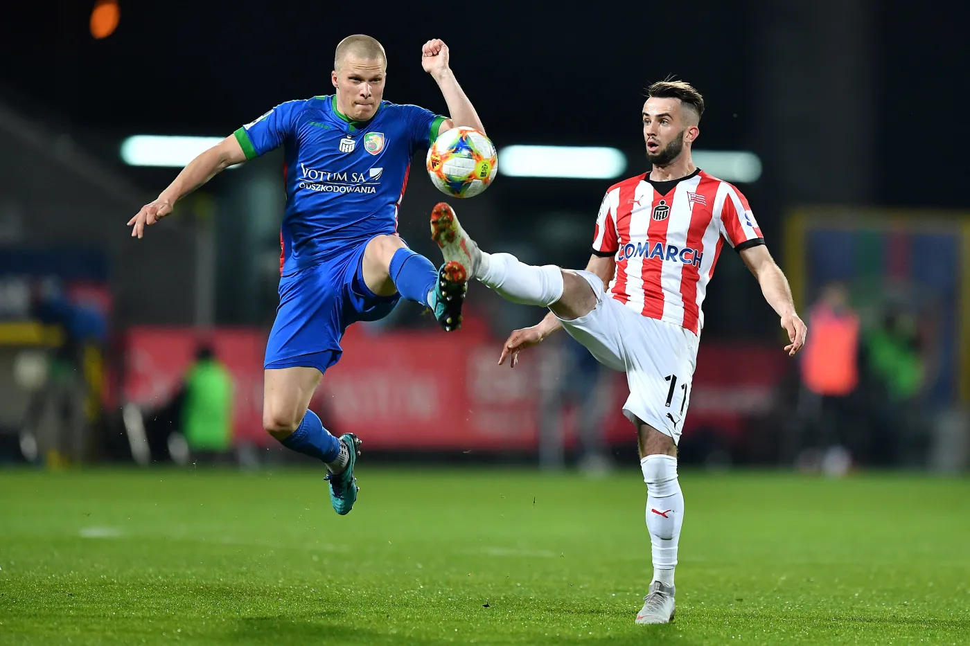 Zawodnik Miedzi Legnica Henrik Ojamaa (L) i Mateusz Wdowiak (P) z Cracovii