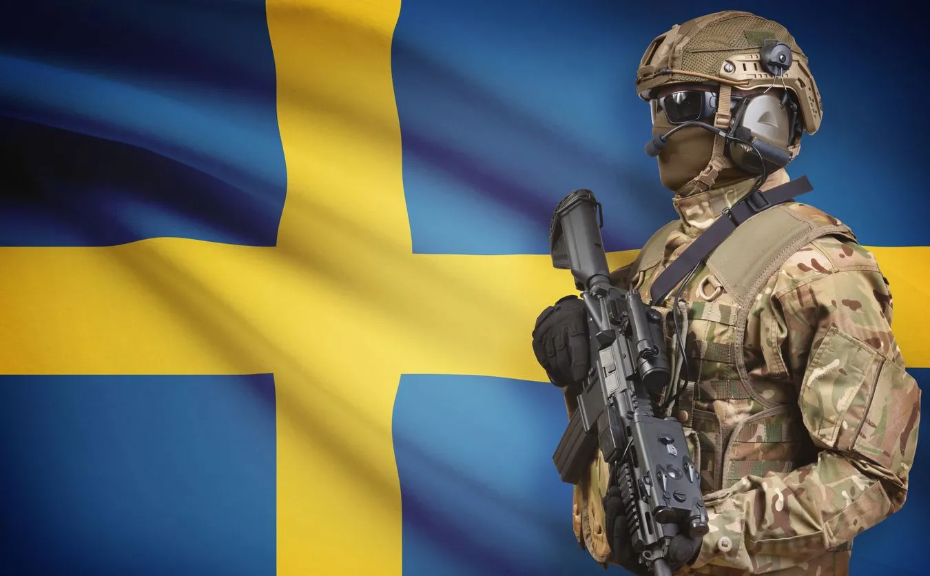 Żołnierz na tle szwedzkiej flagi