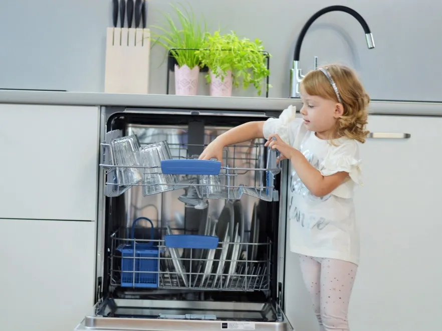 Dziewczynka rozpakowuje zmywarkę