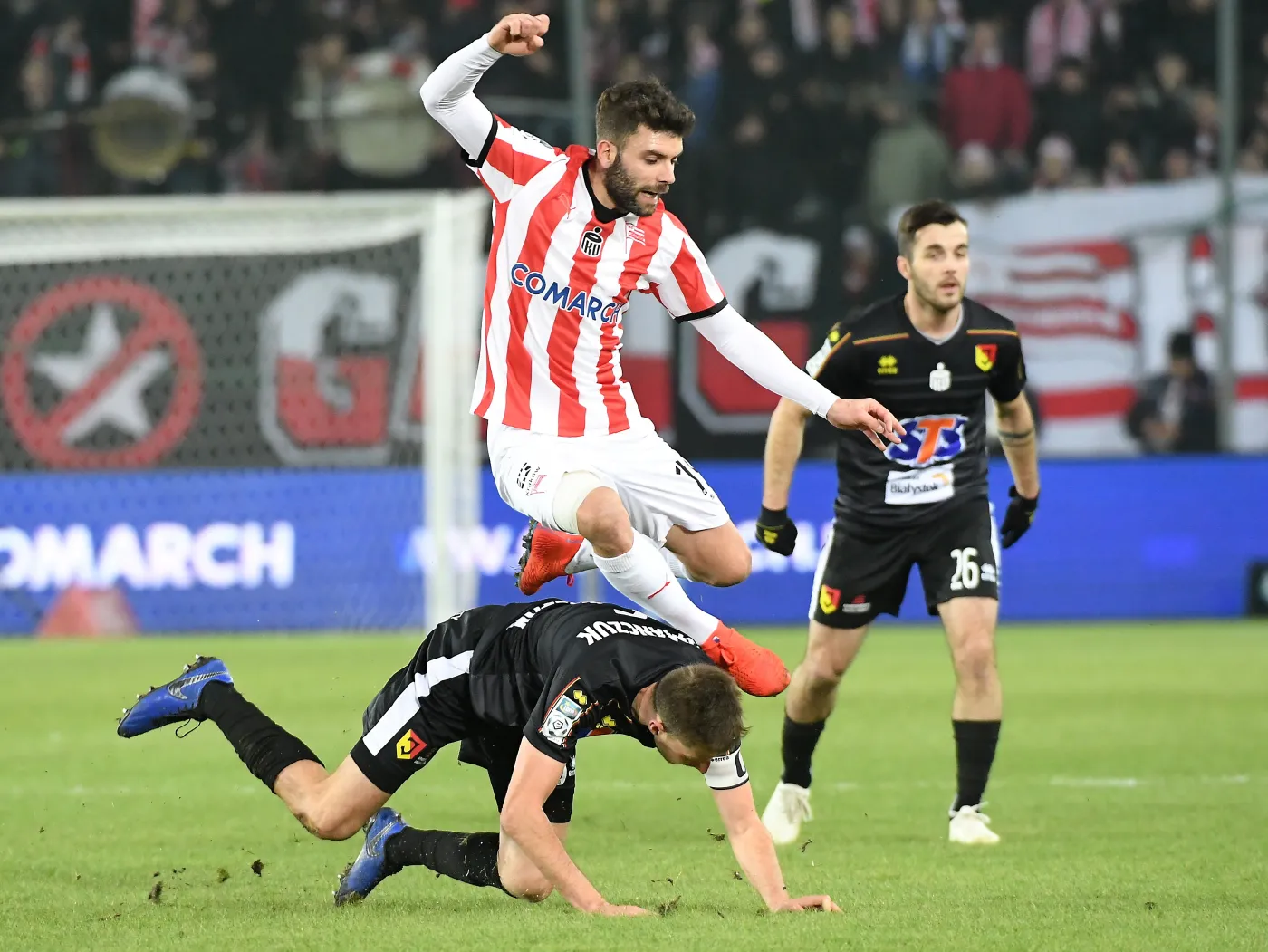 Zawodnik Cracovii Javi Hernandez (C) i Taras Romanchuk (dół) z Jagiellonii Białystok