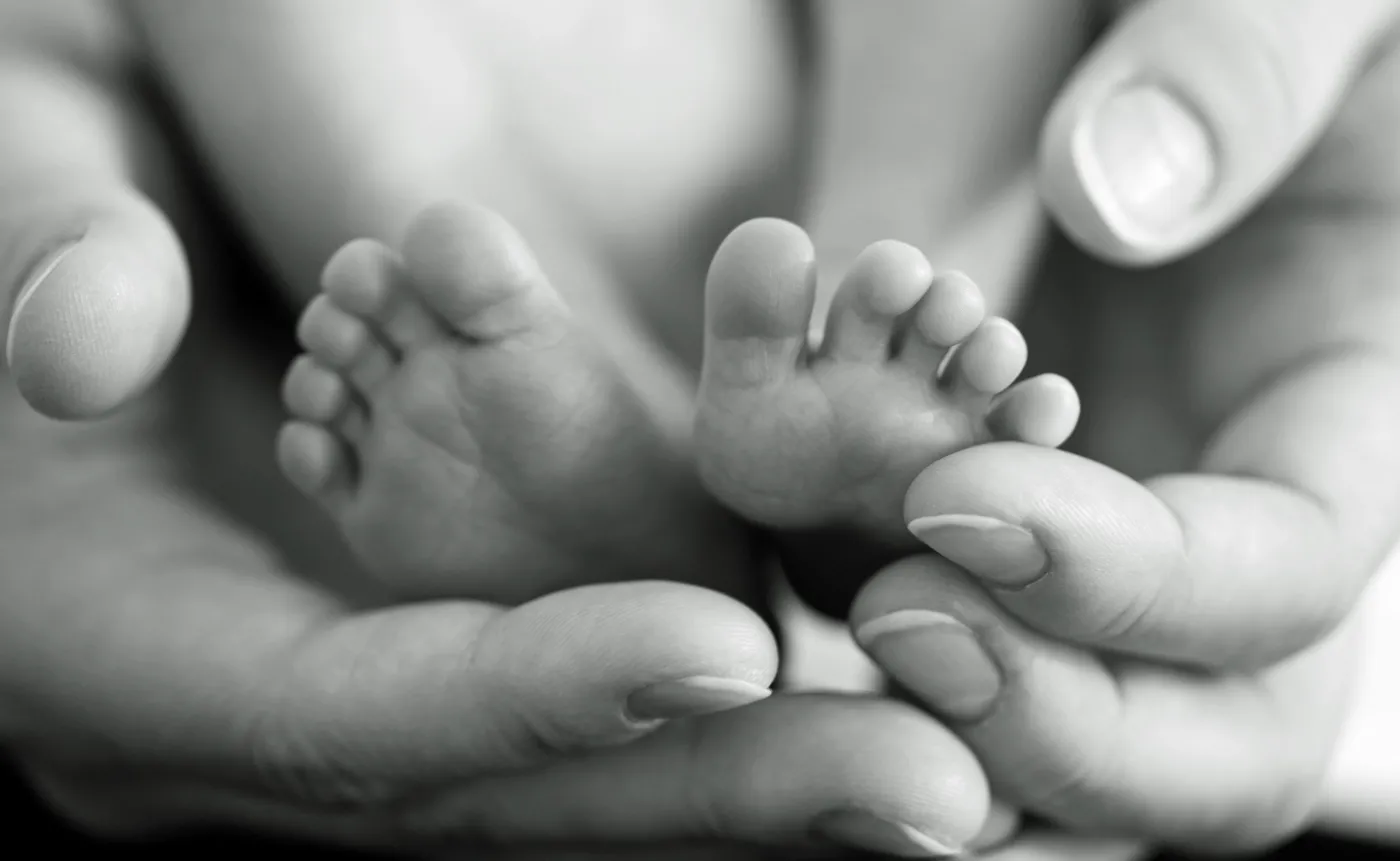 Stopy noworodka w dłoniach mamy