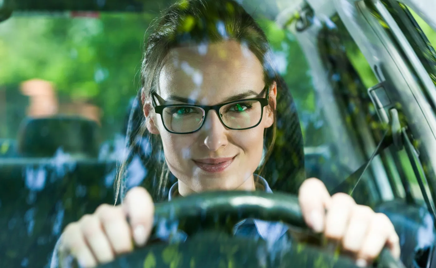 Kobieta w okularach prowadzi samochód