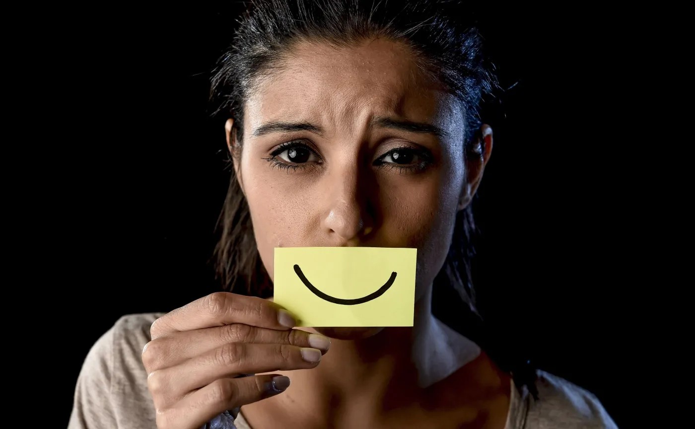 Kobieta z przyklejonym uśmiechem