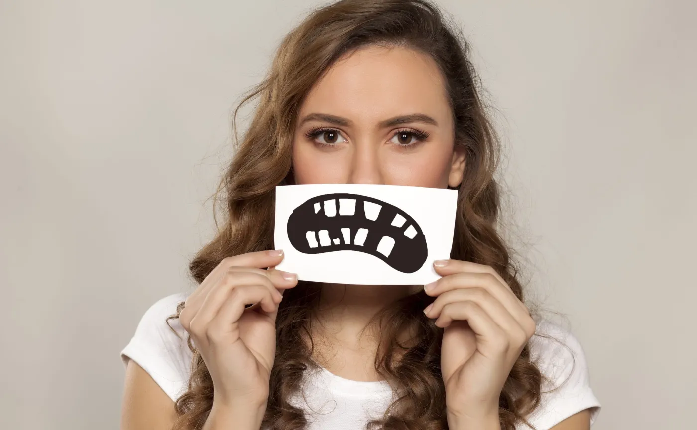 Kobieta pokazuje brzydkie zęby