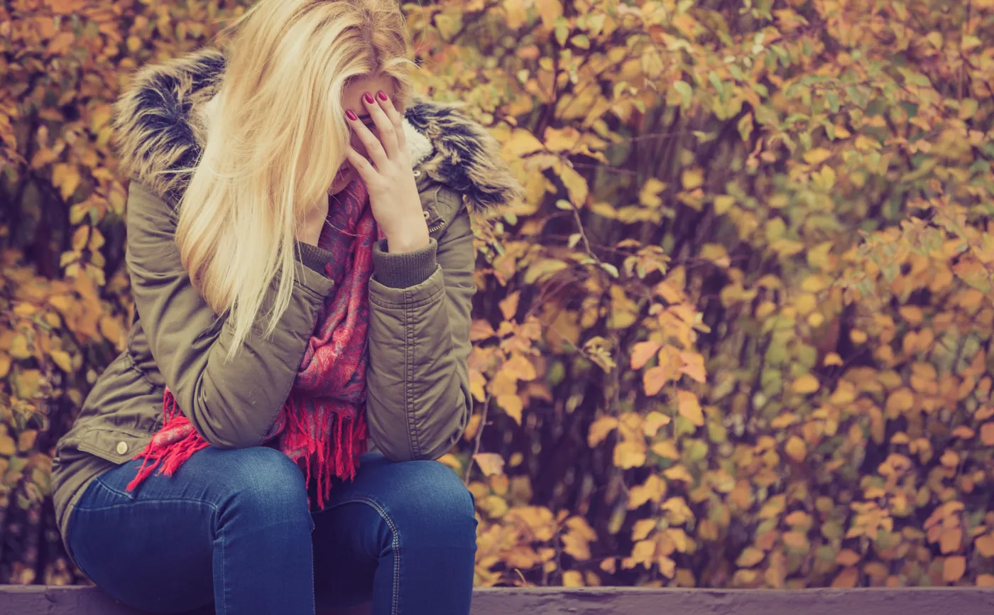 Jesienny spacer: smutna kobieta