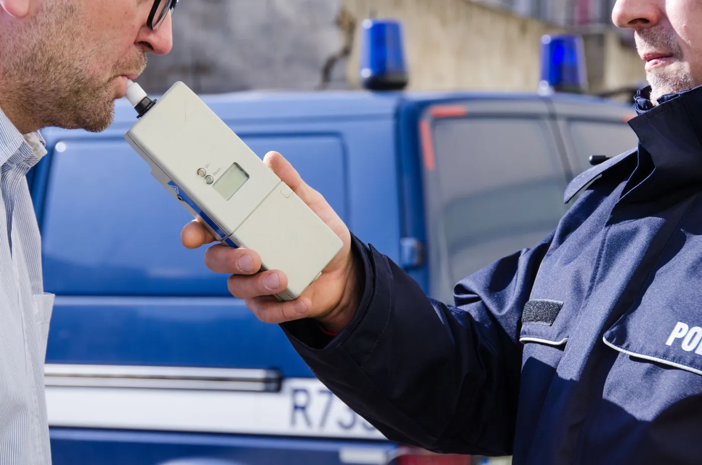 Policjant badający kierowcę alkomatem