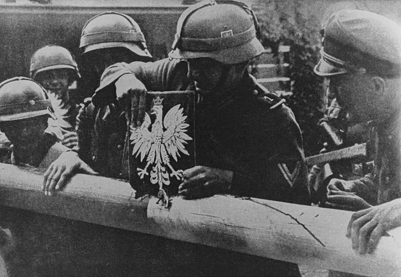 Granica Polski z Wolnym Miastem Gdańskiem (Kolibki). Żołnierze niemieccy niszczą szlaban graniczny i godło Polski. Rozpoczęcie II wojny światowej 1 Września 1939. Źródło: Apoloniusz Zawilski (1972) "Bitwy Polskiego Września", Warszawa: Nasza Księgarnia.
