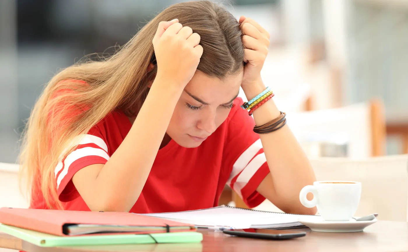 Nastolatka siedzi nad książkami