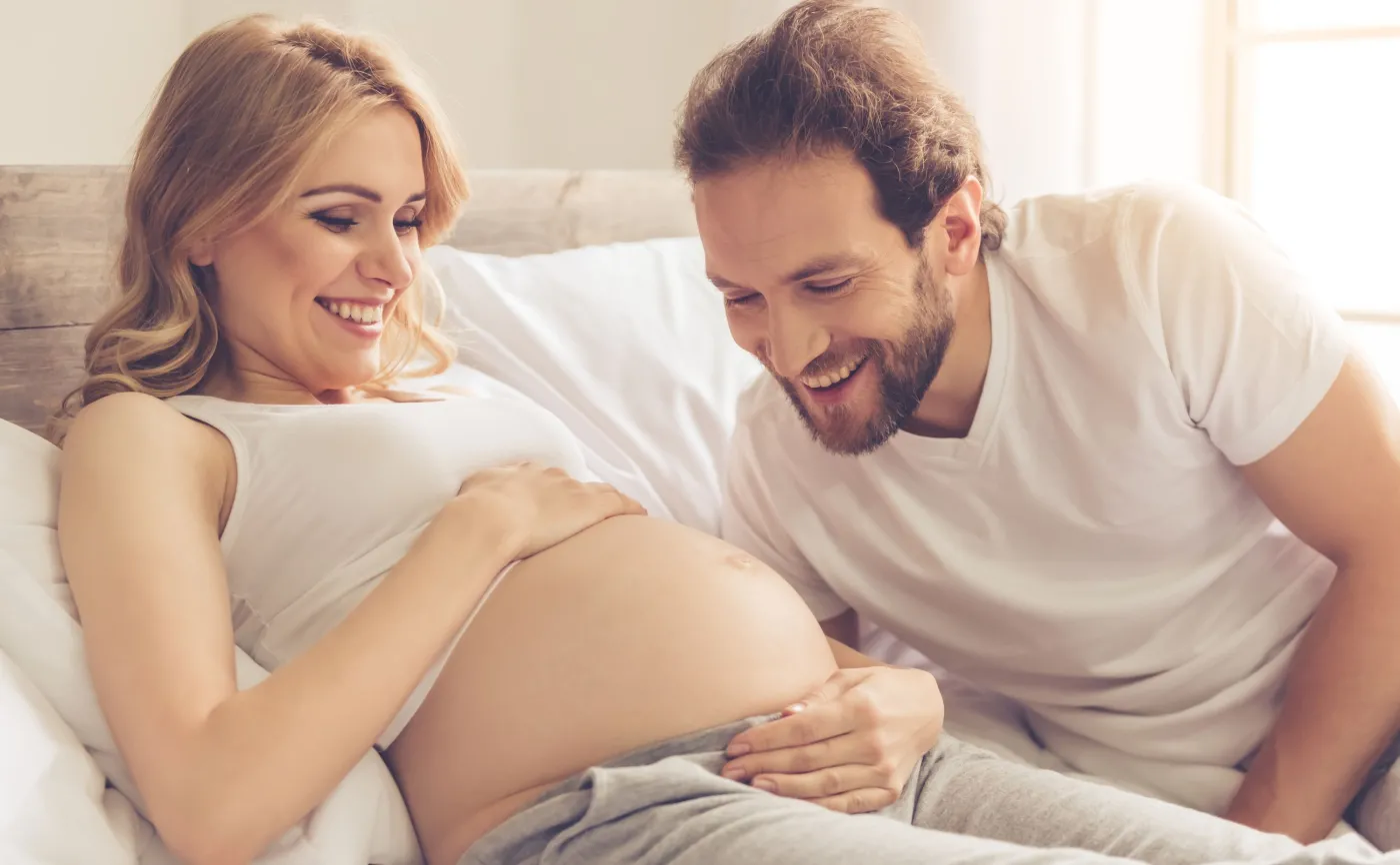Kobieta w ciąży leży z partnerem