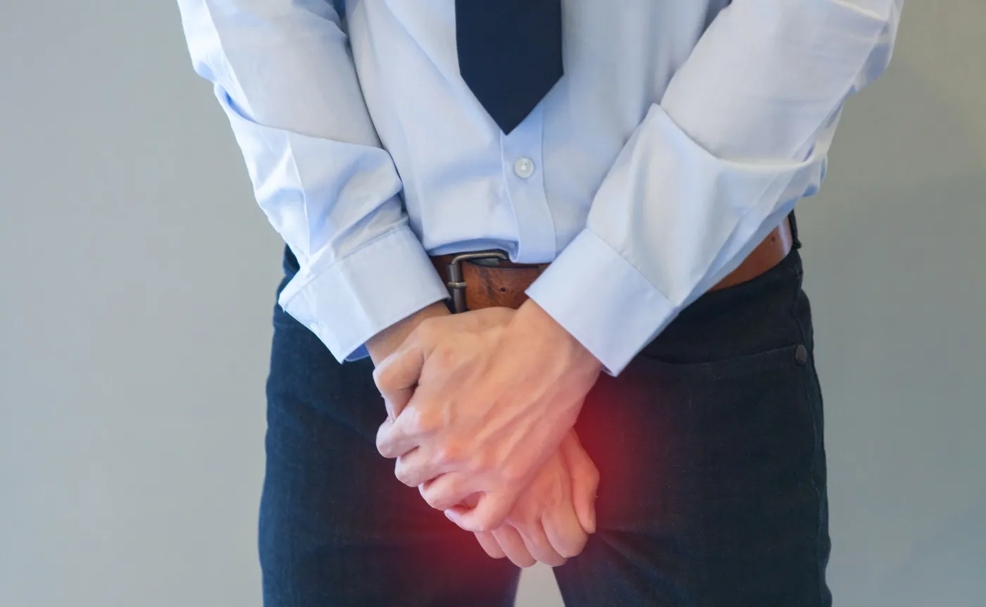 Mężczyzna trzyma się za krocze