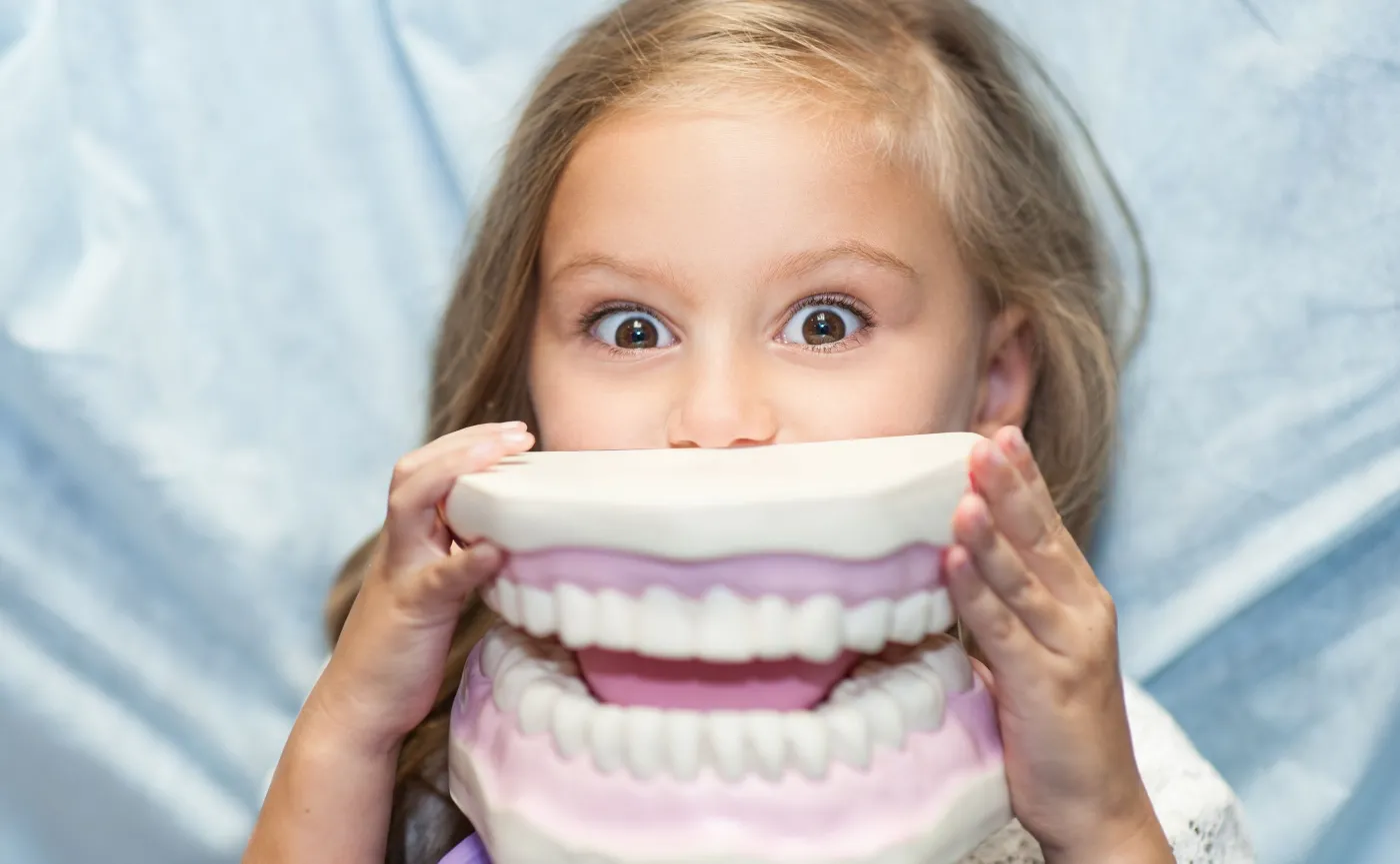 Dziewczynka trzyma atrapę szczęki