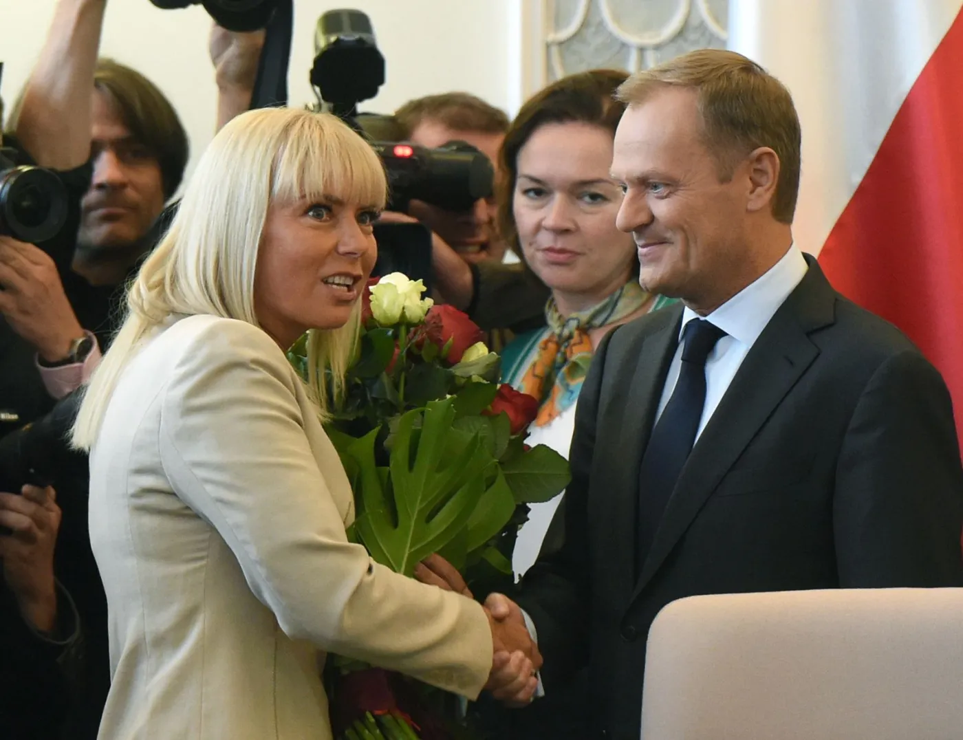 Wicepremier i minister infrastruktury i rozwoju Elżbieta Bieńkowska (L) wręcza premierowi Donaldowi Tuskowi (P) bukiet kwiatów przed posiedzeniem rządu, 2 bm. To pierwsze posiedzenie Rady Ministrów po wyborze premiera Donalda Tuska na szefa Rady Europejskiej. Ministrowie powitali premiera oklaskami. 