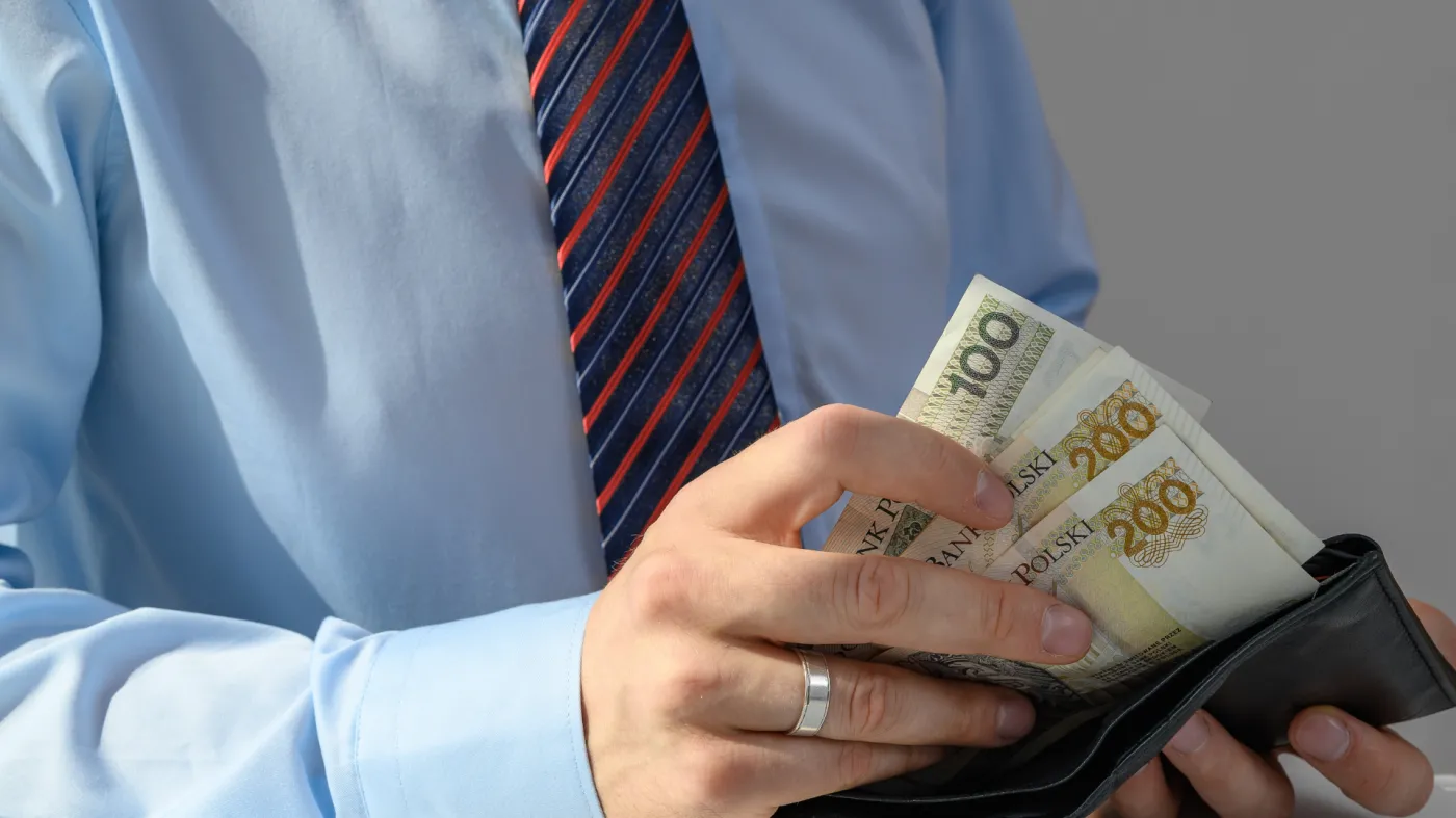 Mężczyzna wyciąga z portfela banknoty