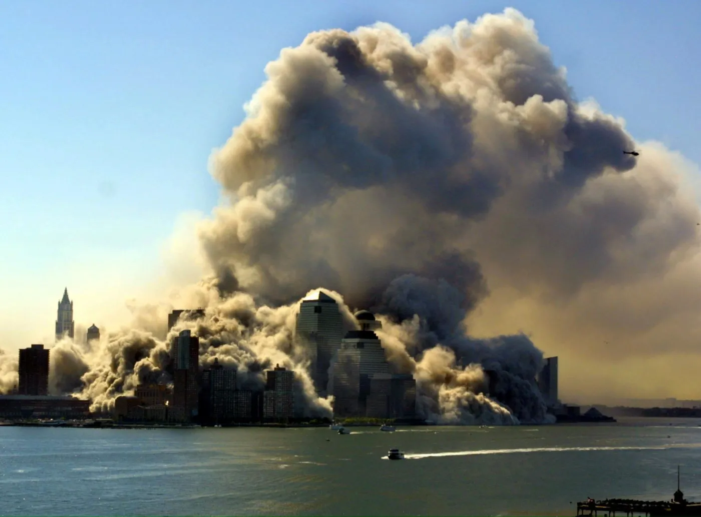 Widok z rzeki Hudson na dwie wieże World Trade Center, zapadające się w wyniku zamachu terrorystycznego