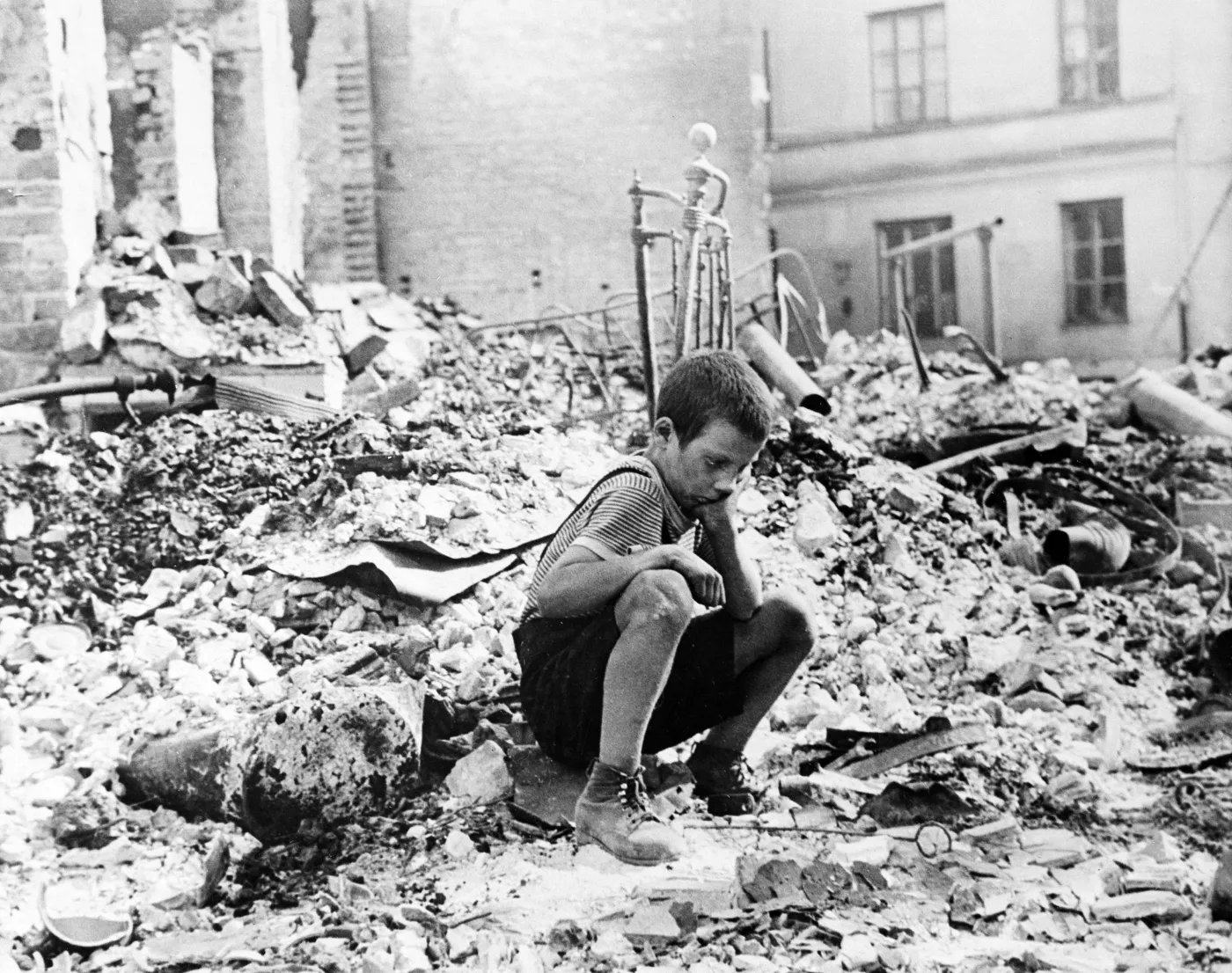 Chłopiec na gruzach domu w Warszawie zbombardowanego we wrześniu 1939 roku przez Niemców