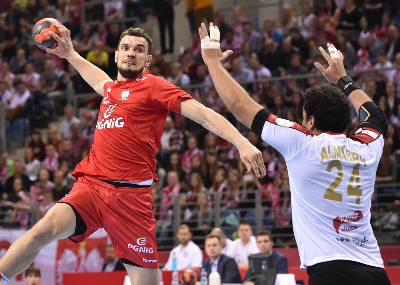 Zawodnik reprezentacji Polski Michał Jurecki (L) szykuje się do rzutu nad Ibrahimem Masry (P) z reprezentacji Egiptu podczas meczu towarzyskiego turnieju w piłce ręcznej mężczyzn, rozgrywanego w Tauron Arenie Kraków