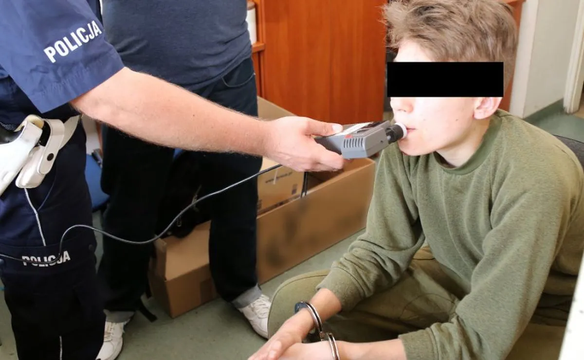 Na zdjęciu archiwalnym udostępnionym przez policję 25 maja 2016 r. policjant sprawdza stan trzeźwości jednego z zatrzymanych, podejrzanego o podłożenie ładunków wybuchowych pod radiowozami policji