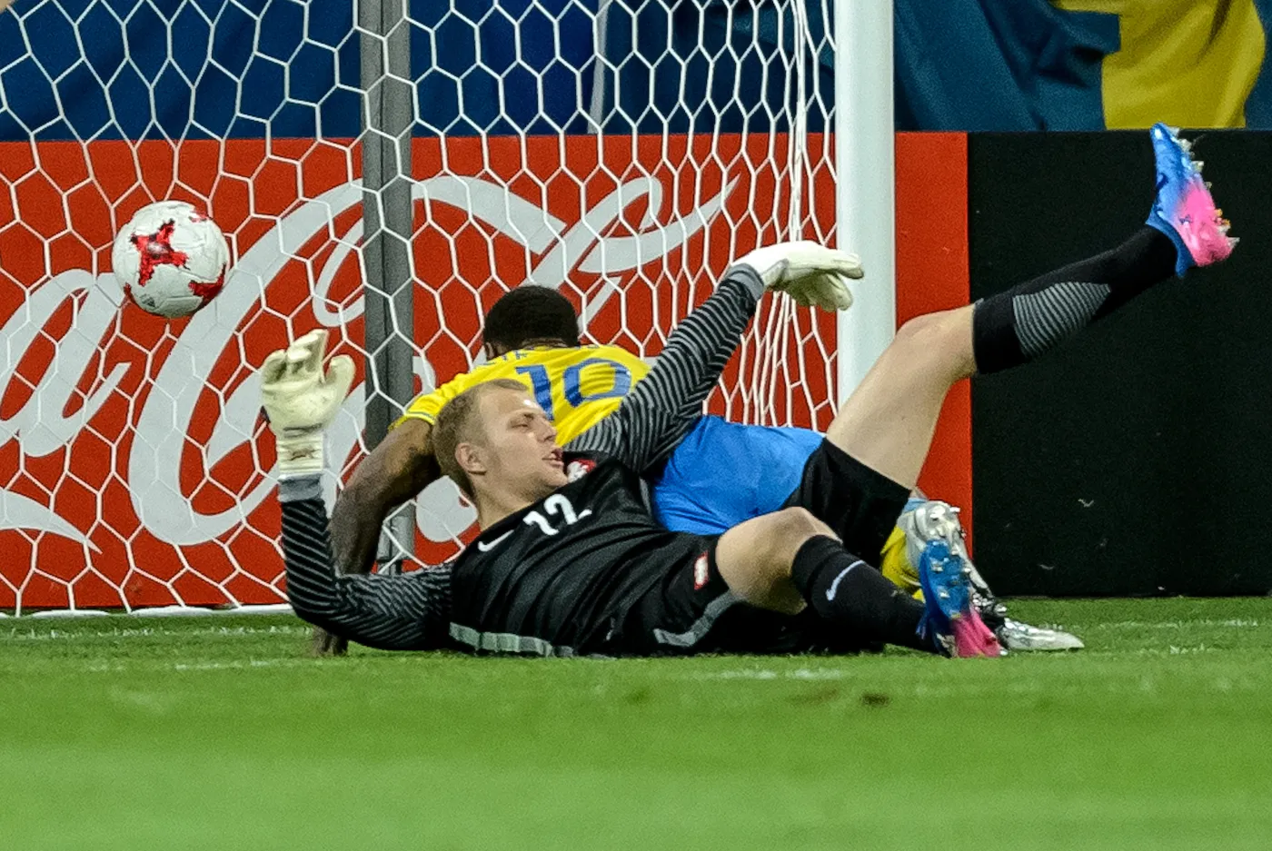 Polski bramkarz Jakub Wrąbel (przód) pokoany przez Szweda Carlosa Strandberga